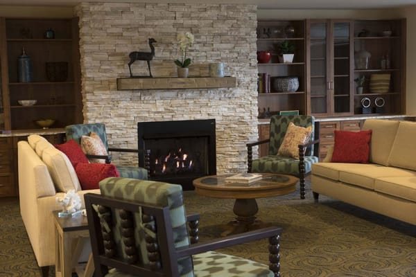 Cozy common area with seating and a stone fireplace