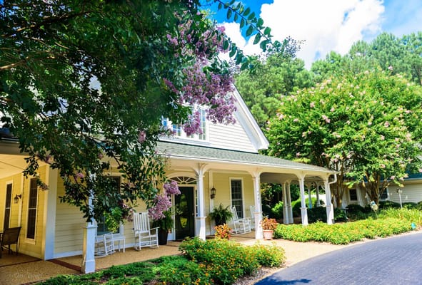 Exterior view of a senior living facility with rocking chairs