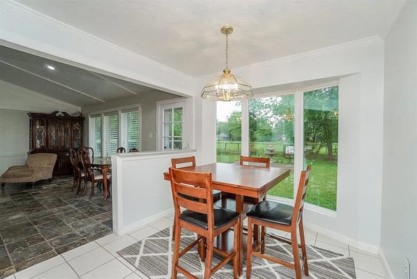 Dining area with wooden table and chairs overlooking the garden