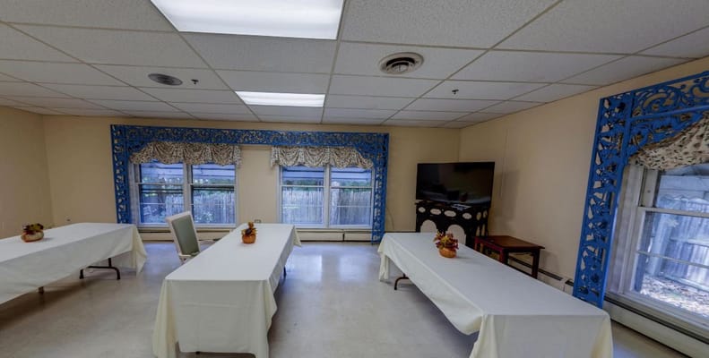 A well-lit activity room with tables and windows