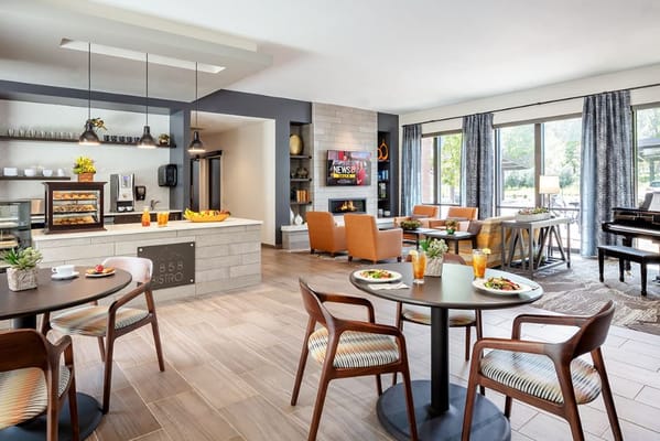 Dining tables in a modern bistro with a view of the seating area and TV.