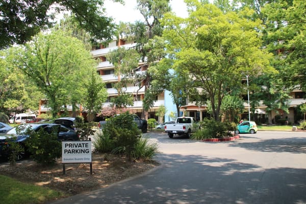Entrance of Eskaton Land Park with parking signs and greenery