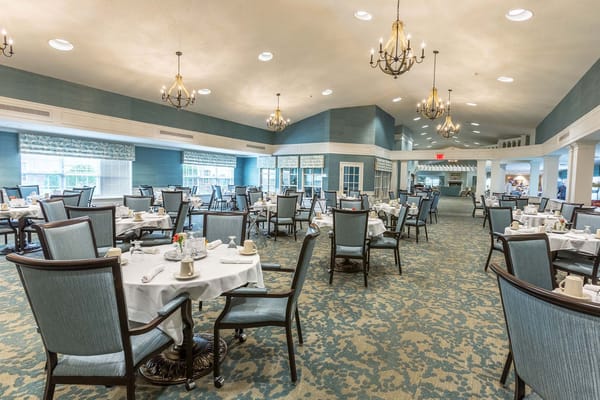 Dining room with tables set for a meal at Independence Village of Brighton Valley.