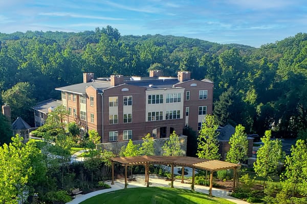 Exterior view of a senior living facility among greenery