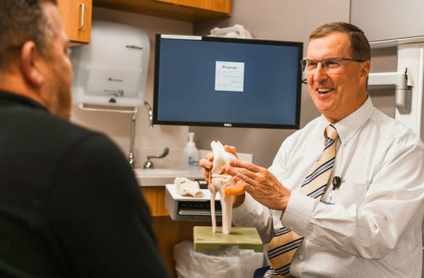 A doctor explaining a model to a patient in an office