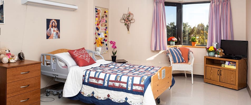 Cozy resident room with bed, dresser, and window view