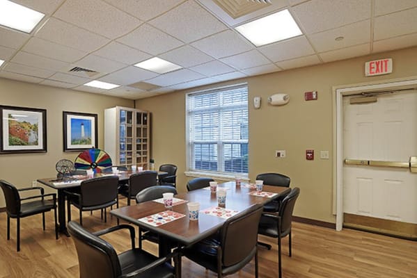 Bright common area with tables and chairs set up for activities