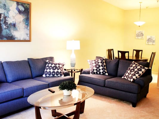 Cozy living room with blue sofas and dining area