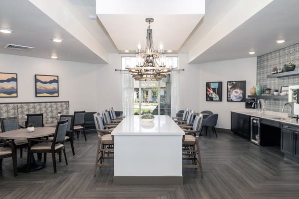 Modern dining area with wooden tables and a large chandelier.
