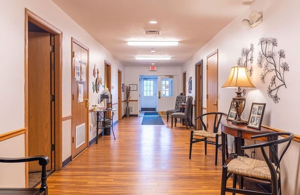 Bright hallway in Marla Vista Assisted Living with wooden floors and doors.