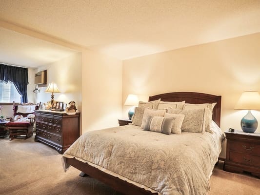 A cozy private resident room with a bed and dresser