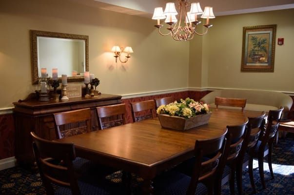 Dining area with a wooden table and floral centerpiece.