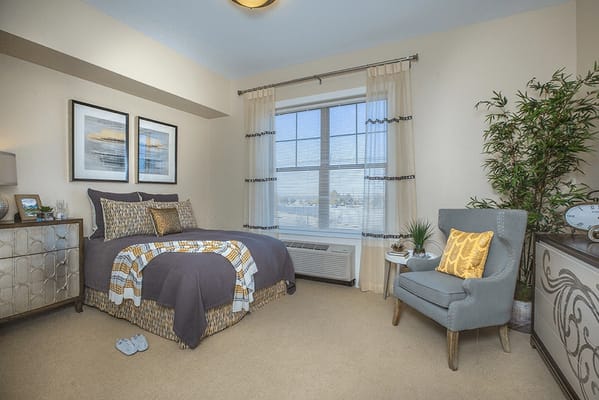 Cozy interior of a private resident room with a bed and chair