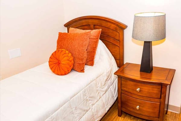 Cozy private bedroom with wooden furniture and pillows