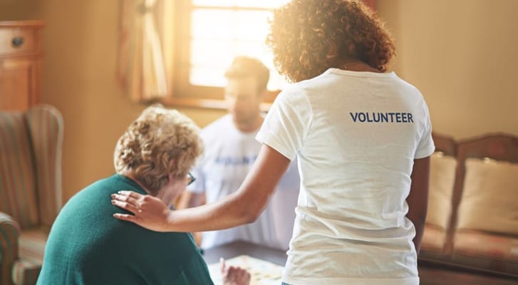 A volunteer helps a resident with a game, fostering interaction and support.