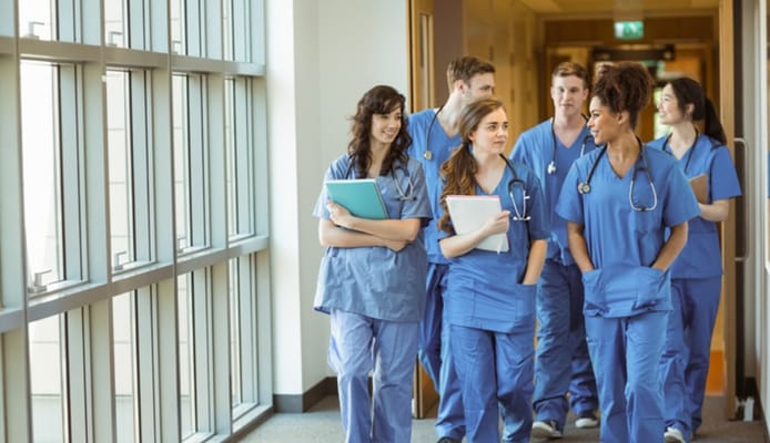 Group of nursing staff walking in hallway