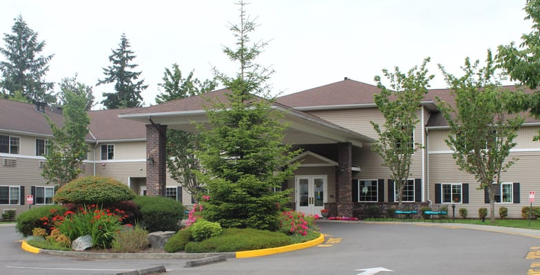 Entrance of a senior living facility with landscaped gardens