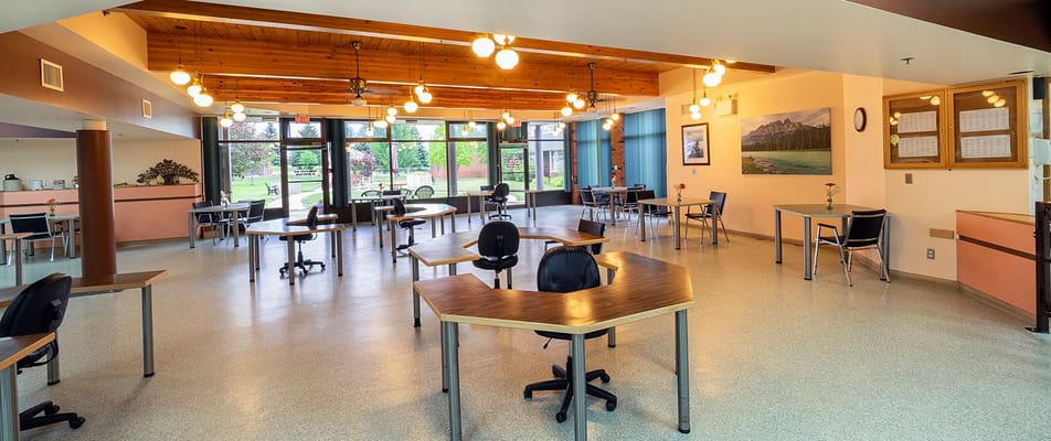 Common area with tables and chairs in a senior living facility
