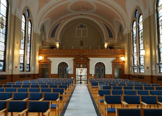 Interior view of a spacious chapel with wooden pews