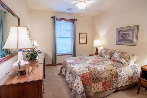 Cozy resident room with a quilted bedspread and natural light