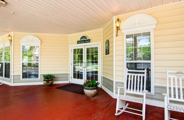 Exterior view of a welcoming entrance with rocking chairs