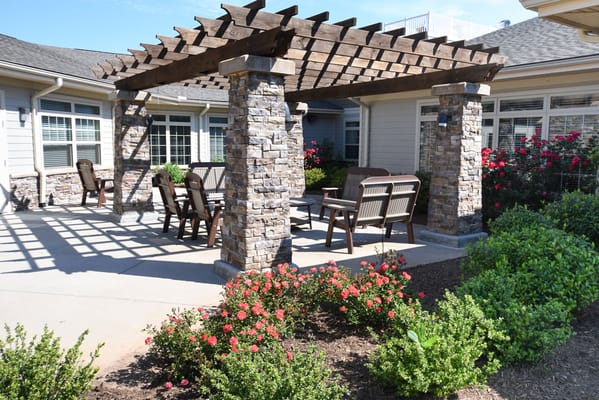 Outdoor seating area with a pergola and flowers