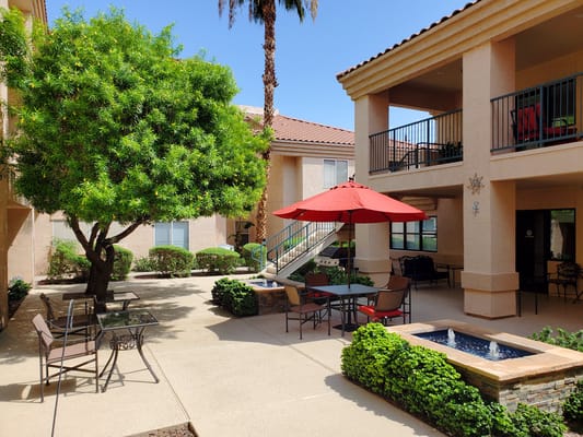 Outdoor courtyard with shaded seating and greenery