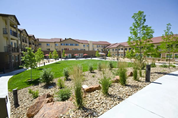 Courtyard view of Palmilla Senior Living with landscaped gardens and outdoor seating.