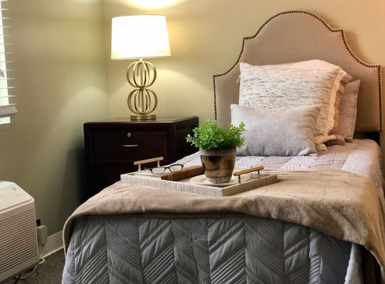 Cozy resident room with bedding and lamp