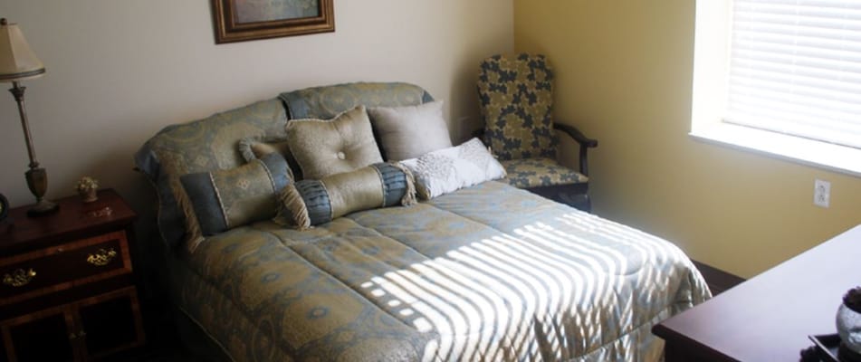 Cozy resident room with a large bed and armchair