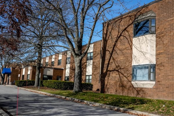 Exterior view of Pawtucket Falls Healthcare Center showing building and trees