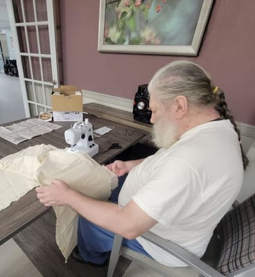 A resident sewing in an activity room
