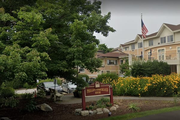Entrance of Phillips-Strickland House with flowers and trees