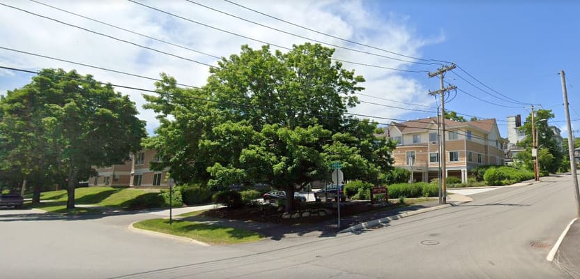 Entrance area of Phillips-Strickland House with trees and signage.