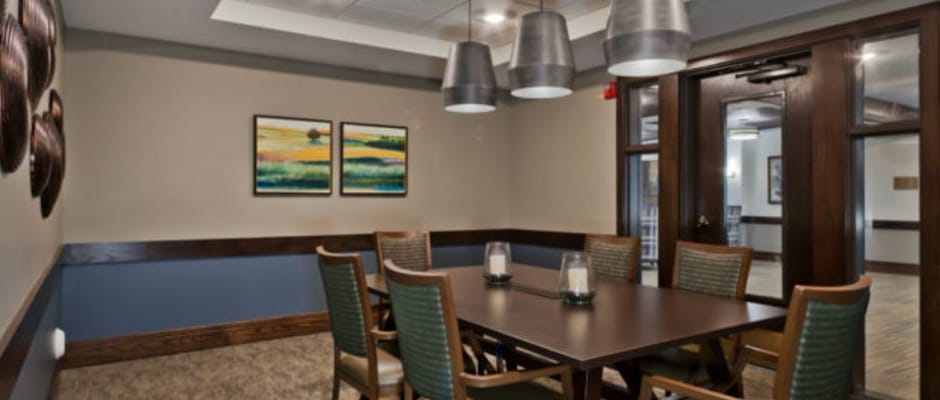 A well-lit common area with a dining table and chairs