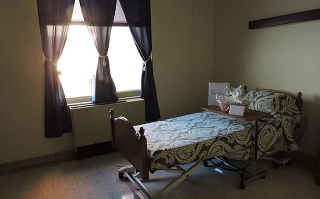 A well-furnished resident room with a bed and window