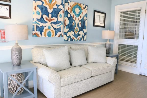 Comfortable sofa with decorative pillows in a light blue living room
