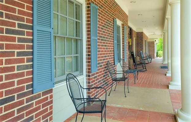 Covered porch with seating area and brick wall