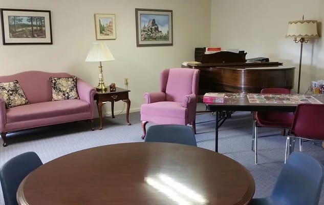 Cozy lounge area with pink sofas and a piano