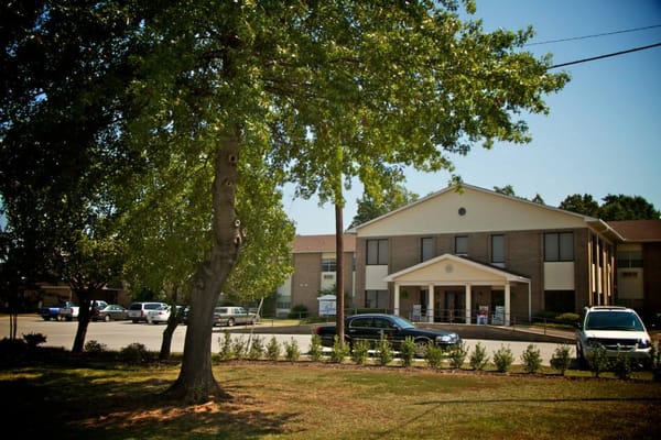 Exterior view of Regency Retirement Village with trees and parking