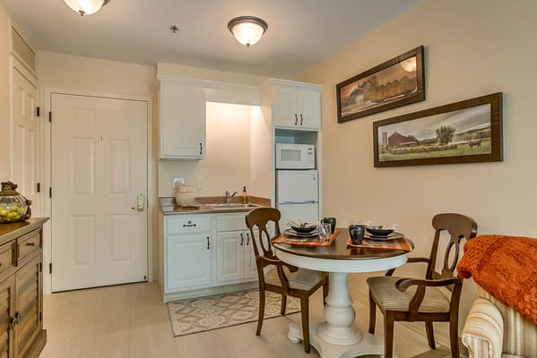 A cozy kitchen and dining area with a table set for two.