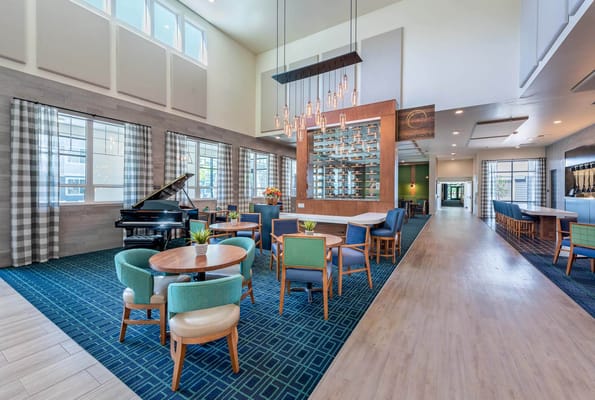 Bright common area with seating and a piano