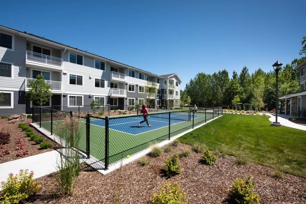 Residents playing tennis in a landscaped outdoor space