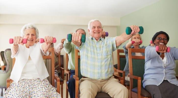Seniors participating in a seated exercise class with weights