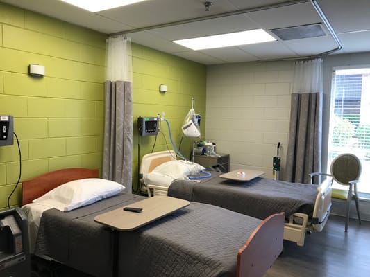 Two resident beds in a bright room with green walls