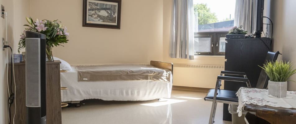A bright resident room with a bed and seating area