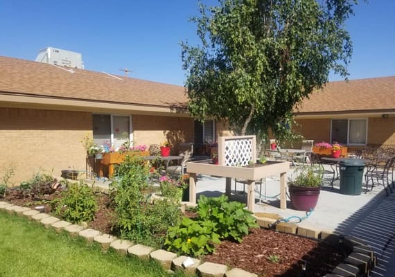 Bright garden area with flowers and seating at Sage View Care Center.