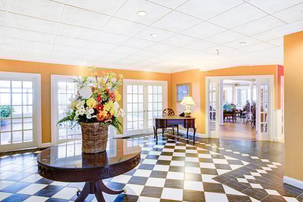 Interior view of a bright common area with floral arrangement