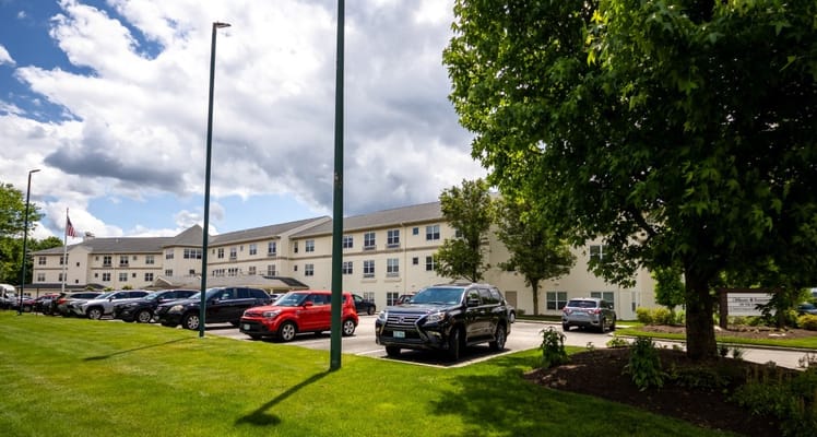 Exterior view of a senior living facility with cars in the parking lot