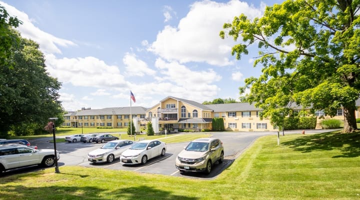 Exterior view of Capitol Ridge at Providence with parking lot and trees.